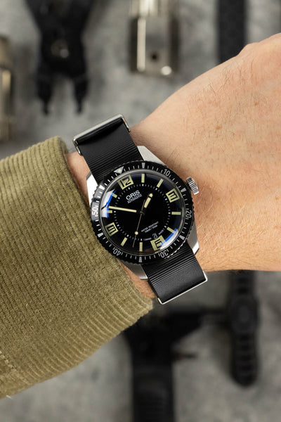 Oris diver 65 black dial fitted with black bonetto centurini 328 rubber one piece watch strap worn on wrist with khaki shirt