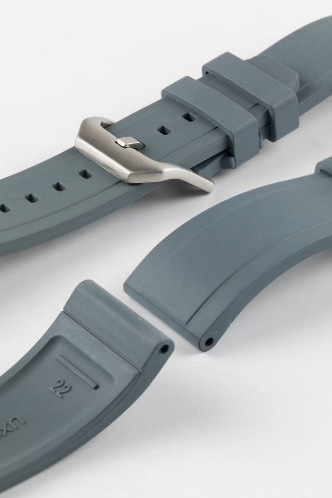 Product photo on the UX03 Rubber FKM watch strap showing the buckle done up in brushed steel, next to the underside of the strap showing the lug holes and curved fitting for comfort