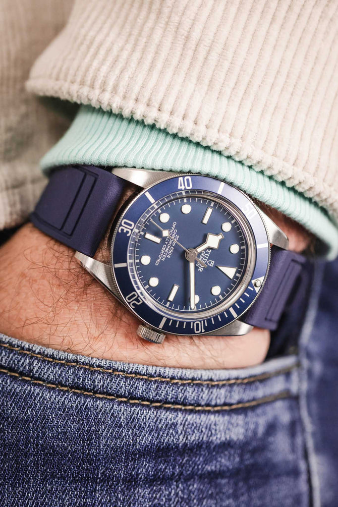 Pocket shot of a Tudor Black Bay 58 Blue in jeans pocket with turquoise hoodie and cream cord shirt, the watch is fitted to a blue rubber strap