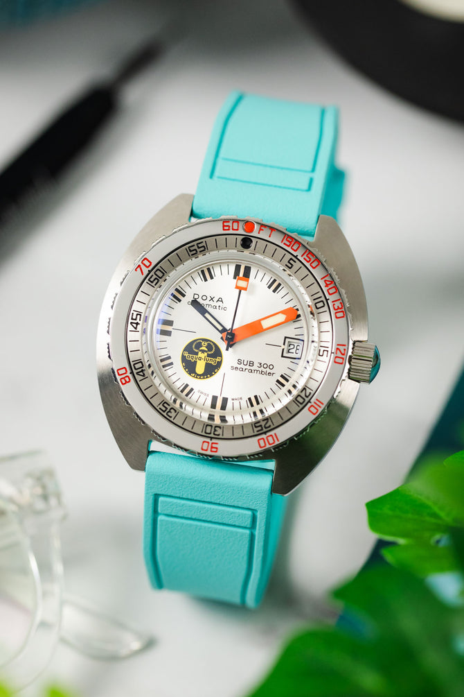 Bright turquoise watch strap fitted to Doxa dive watch with orange and yellow dial details