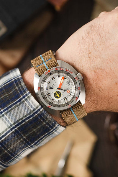 Doxa dive watch fitted to a desert sand webbing strap